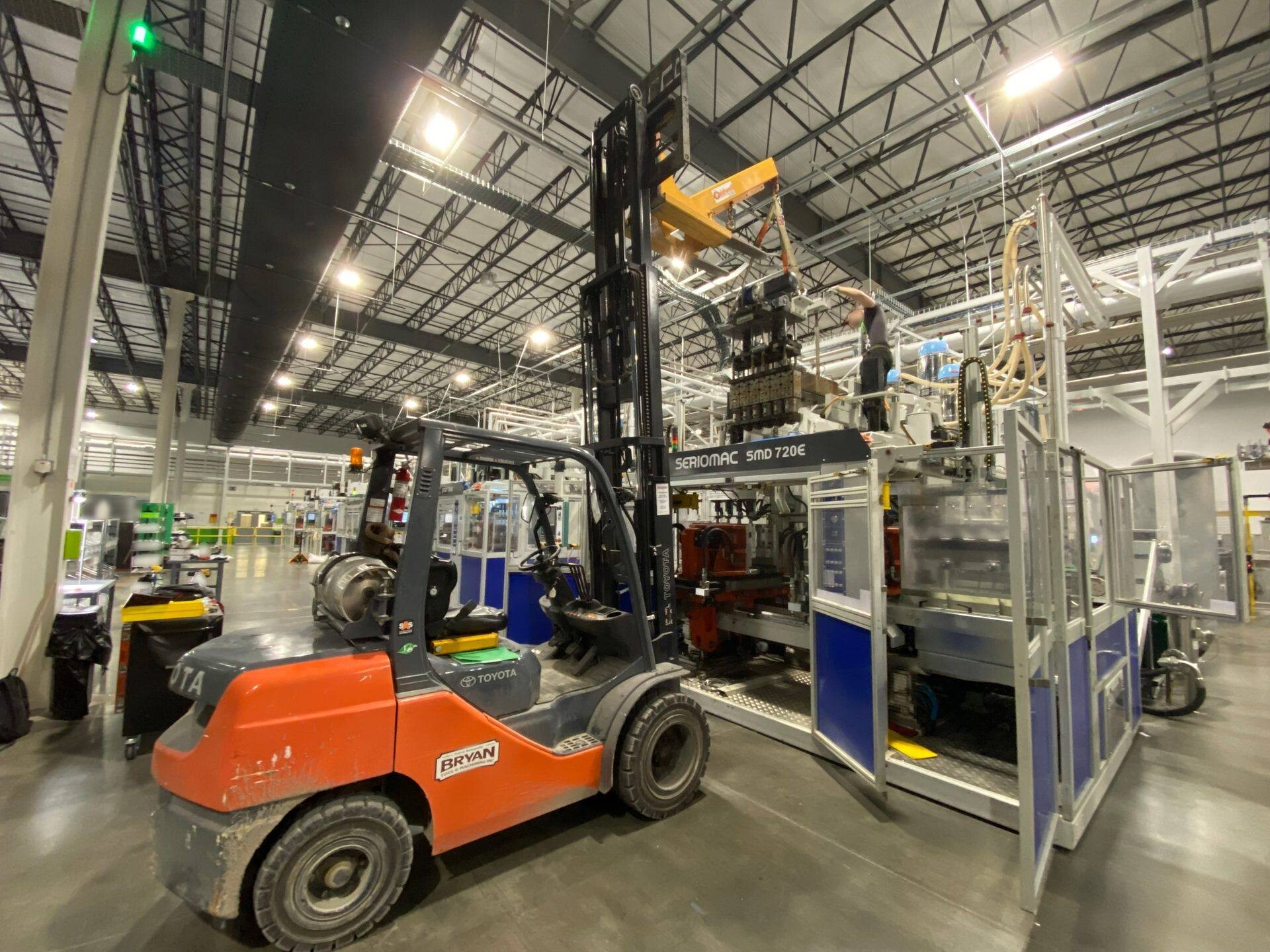 Boom-equipped forklift positioning an extruder head