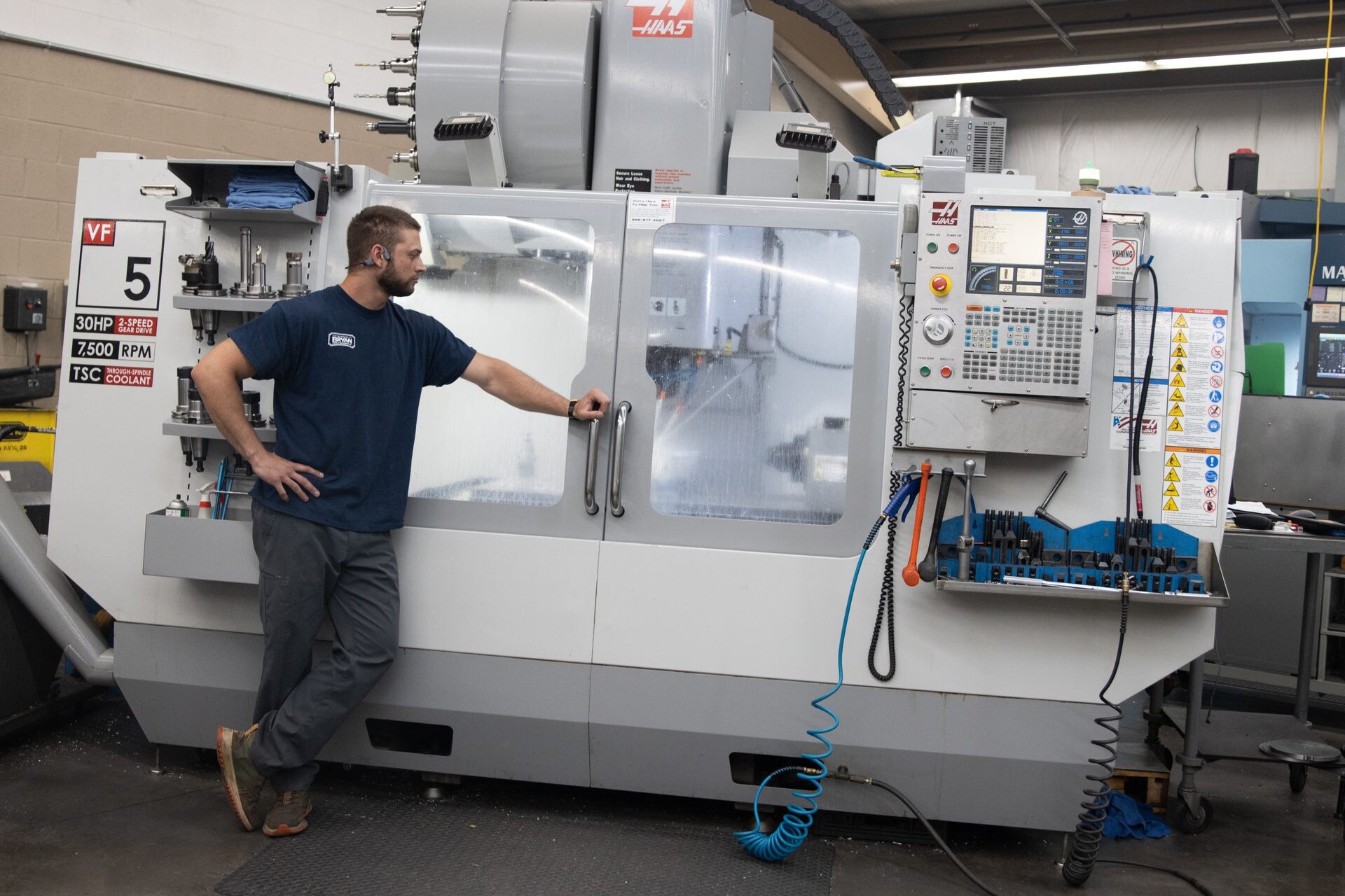 A Bryan Tool machinist at his CNC turning center