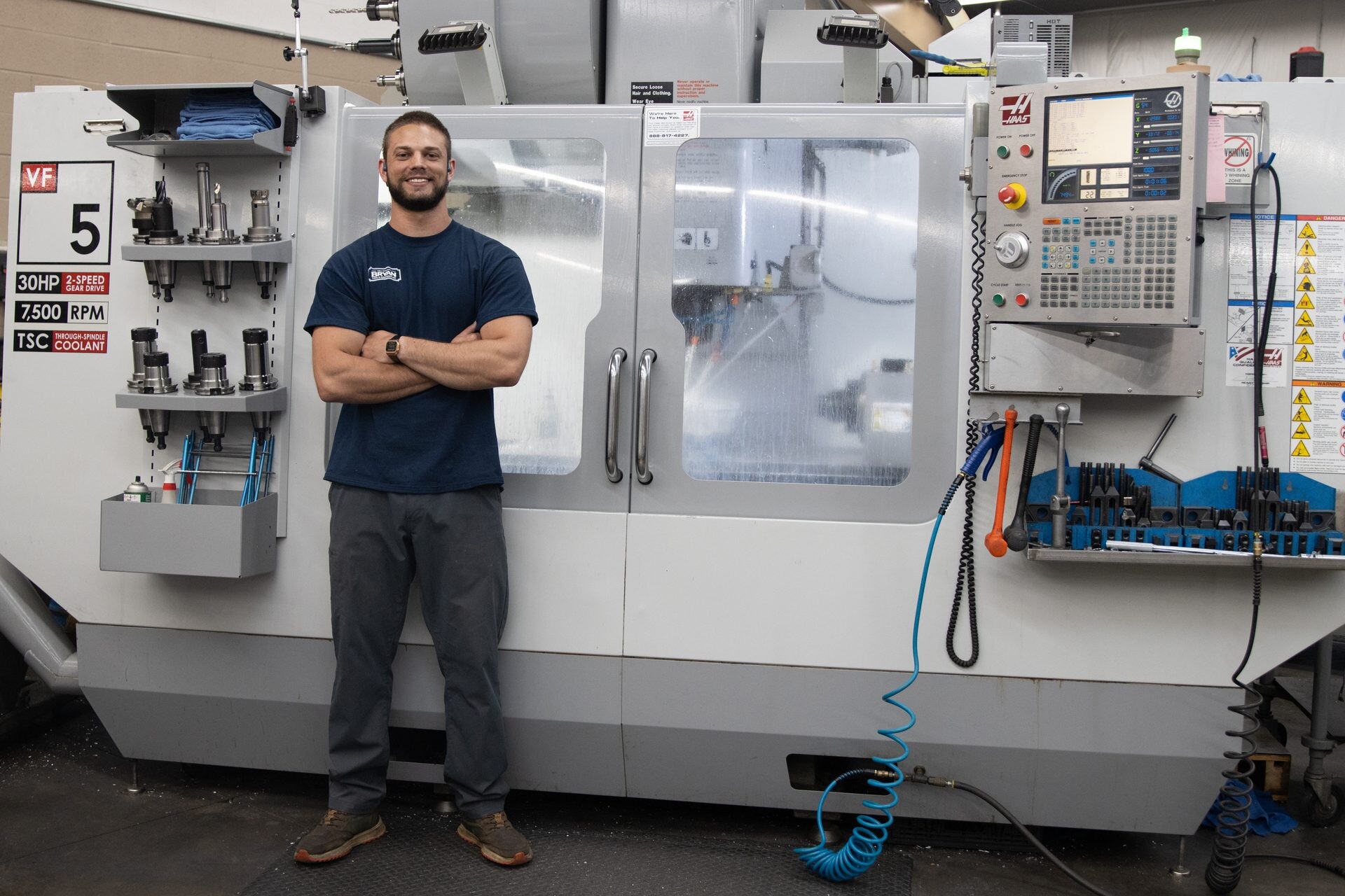 A Bryan Tool machinist in front of his Haas CNC machining center